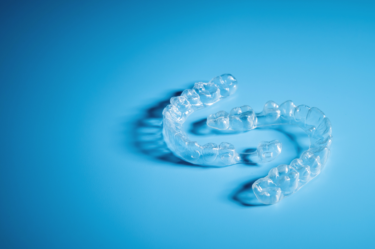 Plastic dental orthodontics on colored background. No people
